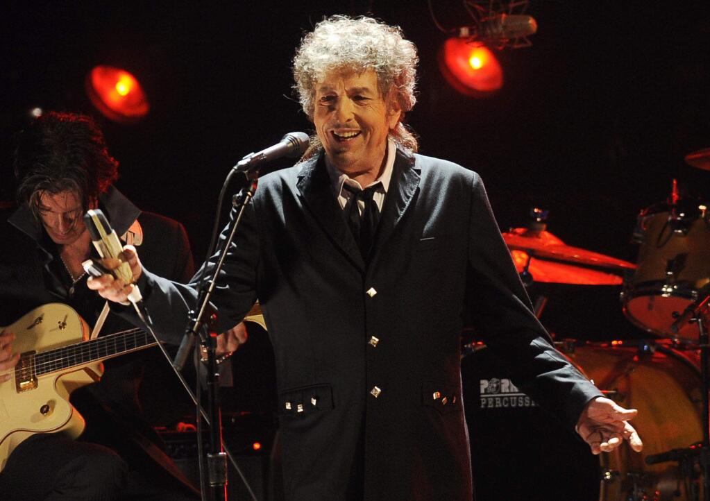 FILE - In this Jan. 12, 2012, file photo, Bob Dylan performs in Los Angeles. Dylan, who was named the winner of the 2016 Nobel Prize in literature on Oct. 13, 2016, says he “absolutely” wants to attend the Nobel Prize Award Ceremony “if it's at all possible” in December, finally breaking his silence about earning the prestigious honor. (AP Photo/Chris Pizzello, File)