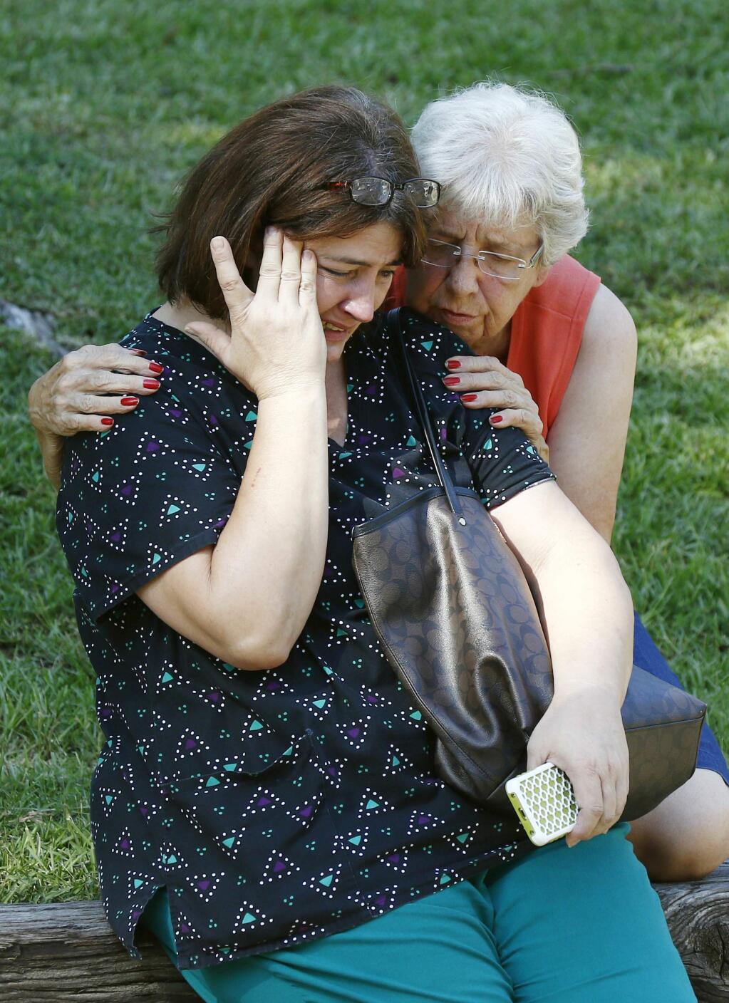 Jonell Payton, right, comforts Lisa Dew, outside the Durant, Miss., home of two slain Catholic nuns, Thursday, Aug. 25, 2016. The nuns worked as nurses at the Lexington Medical Clinic, where Dew was the office manager. Dew and a Durant police officer discovered their bodies inside the house after both nuns did not report for work. (AP Photo/Rogelio V. Solis)