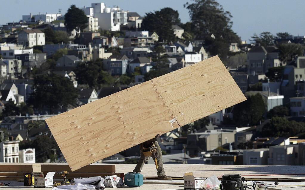 FILE - In this March 28, 2018, file photo, a construction crew works on a roof in San Francisco. California officials announced Friday, Aug. 16, 2019, that job growth in the world's fifth largest economy is now in its 113th month, tying the expansion of the 1960s as the longest on record. The country's most populous state needs between 8,000 and 9,000 new jobs each month to keep up with its growing workforce. But for the past nine years, California has averaged 29,200 new jobs each month, according numbers released Friday by the state Employment Development Department. (AP Photo/Jeff Chiu, File)