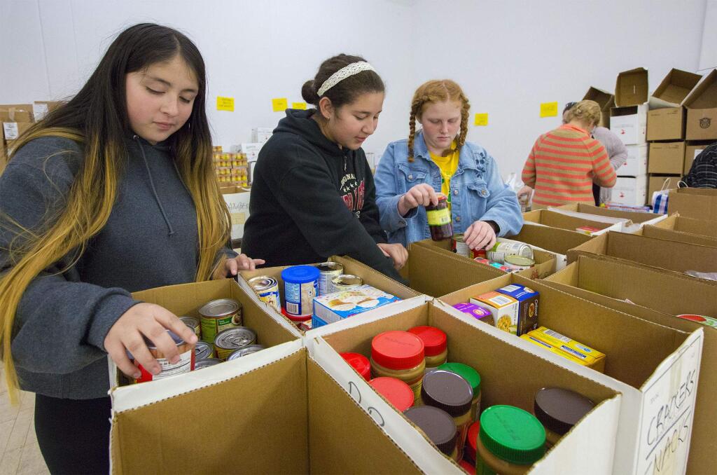 Robbi Pengelly/Index-TribuneFrom left, Yeraldi Rojas, 12, Wendy Eusebio, 13, and Gianna Gruenhagen, all Adele Harrison Middle School students, volunteer their time after school to help F.I.S.H. (Friends in Sonoma Helping) sort donated foodstuffs for the annual holiday food-basket giveaway. Adele Harrison was the founder of F.I.S.H., a volunteer organization that provides food, shelter, clothing and other services to those in need.