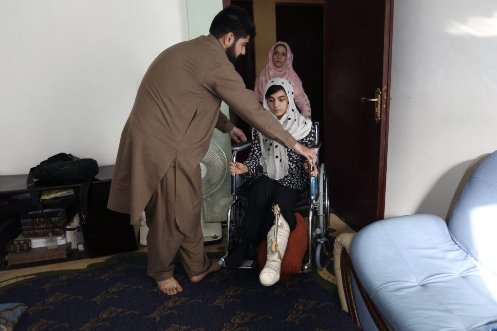 FILE - In this Friday, Oct. 7, 2016, file photo, Breshna Mosazai, 26, a law student of the American University of Afghanistan, where she was wounded in a Taliban attack, arrives for an interview with the Associated Press at her home in Kabul, Afghanistan. Afghanistan's Taliban announced the start of their spring offensive Friday, promising to build their political base in the country while focusing military assaults on coalition and Afghan security forces. (AP Photo/Rahmat Gul, File)