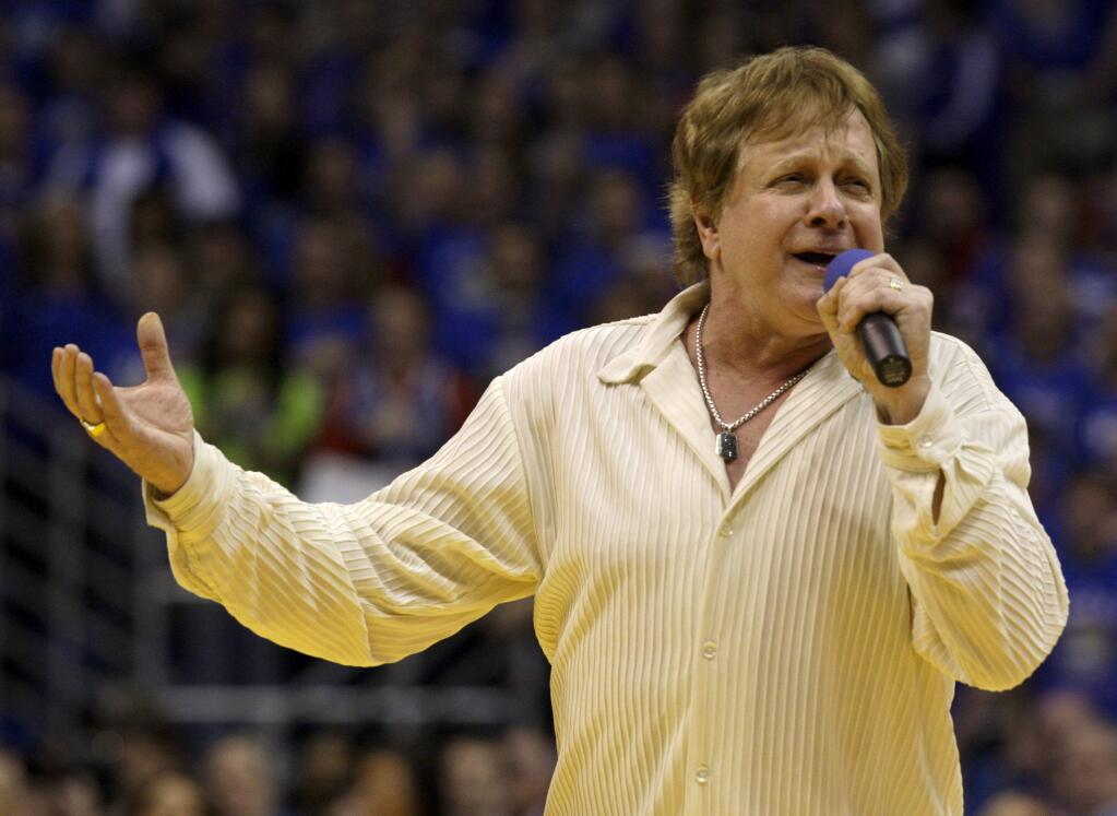 FILE - In this Jan. 25, 2010 file photo, Eddie Money sings the national anthem before an NCAA college basketball game between Kansas and Missouri in Lawrence, Kan. Family members have said Eddie Money has died on Friday, Sept. 13, 2019. (AP Photo/Charlie Riedel, File)