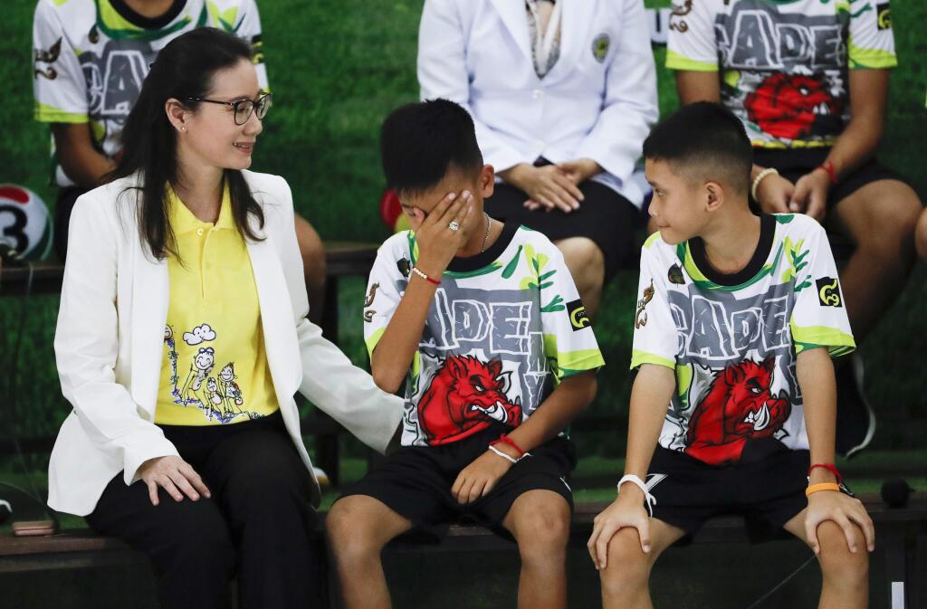 Rescued soccer player 'Titan' Chanin Vibulrungruang reacts after paying respect to a portrait of Saman Gunan, the Thai Navy SEAL diver who died in the rescue attempt, during a press conference discussing their ordeal in Chiang Rai, northern Thailand, Wednesday, July 18, 2018. The 12 boys and their soccer coach rescued after being trapped in a flooded cave in northern Thailand are recovering well and are eager to eat their favorite comfort foods after their expected discharge from a hospital soon. (AP Photo/Vincent Thian)