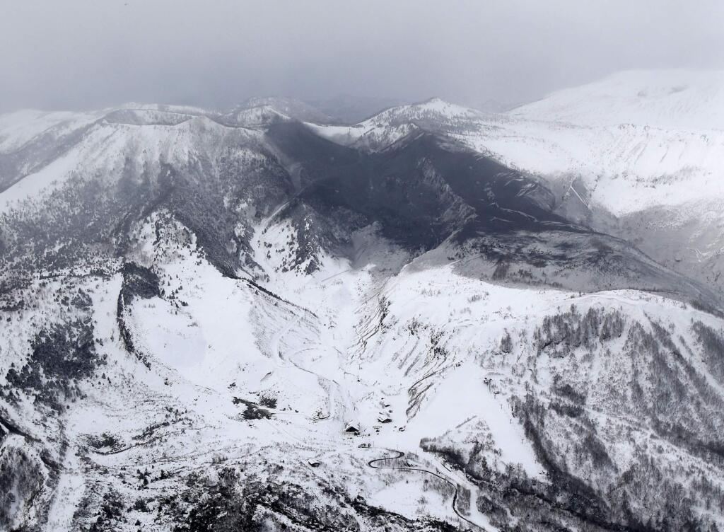 Ashes from Mount Kusatsu-Shirane cover near its summit after its eruption in Kusatsu, Gunma prefecture, central Japan, Tuesday, Jan. 23, 2018. A disaster official said the volcano erupted and caused avalanche near the ski resort. (Suo Takekuma/Kyodo News via AP)