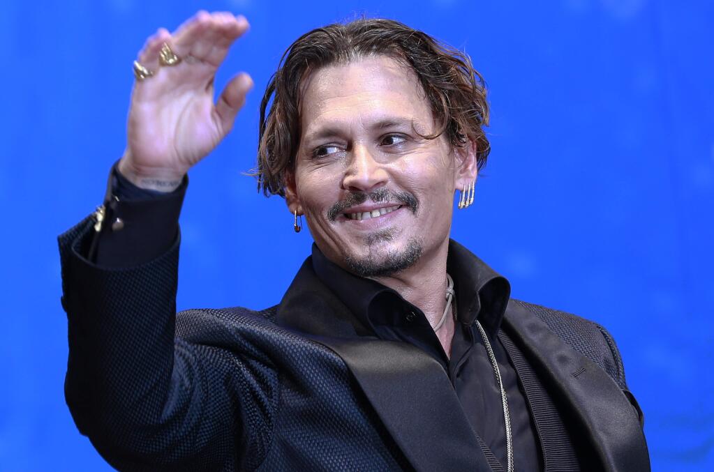 U.S. actor Johnny Depp waves for fans upon his arrival at the Japan premiere of his film 'Pirates of the Caribbean: Dead Men Tell No Tales' in Tokyo, Tuesday, June 20, 2017. (AP Photo/Shizuo Kambayashi)