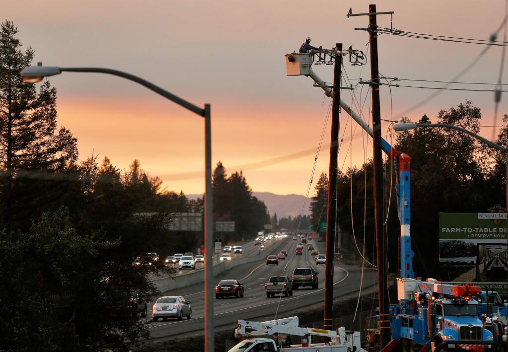 A PG&E linesman prepares to string power line across Highway 101 and restore electricity to parts of north Santa Rosa, California on Wednesday, October 11, 2017. (Alvin Jornada / The Press Democrat)