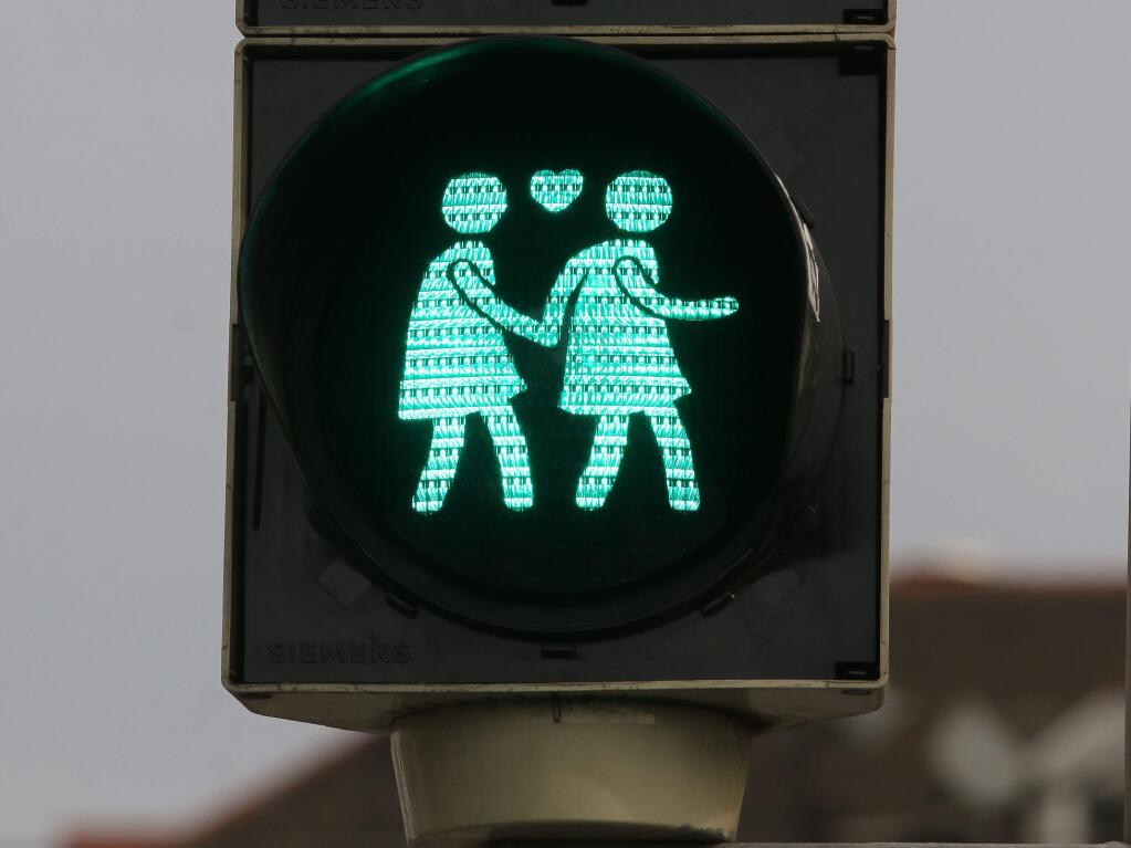 A street light with a same gender pair is pictured in dowtown Vienna, Austria, May 12, 2015. These lights were set up by city officials until June, just in time for the annual Life Ball, where celebrities will rub shoulders with party-goers dressed in little more than body paint and cross-dressers in wild costumes at the charity event supporting AIDS research. (AP Photo/Ronald Zak)
