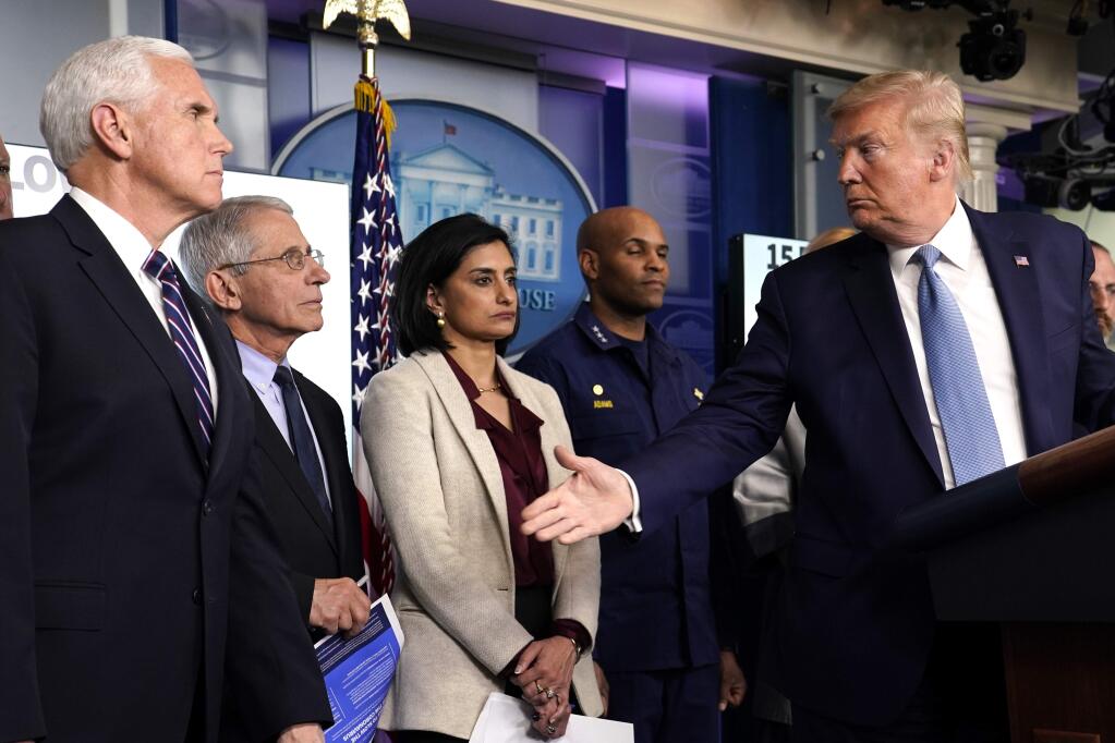 President Donald Trump gestures to Dr. Anthony Fauci, director of the National Institute of Allergy and Infectious Diseases, during a press briefing with the coronavirus task force, in the Brady press briefing room at the White House, Monday, March 16, 2020, in Washington. Watching are Vice President Mike Pence,Administrator of the Centers for Medicare and Medicaid Services Seema Verma, and U.S. Surgeon General Jerome Adams. (AP Photo/Evan Vucci)