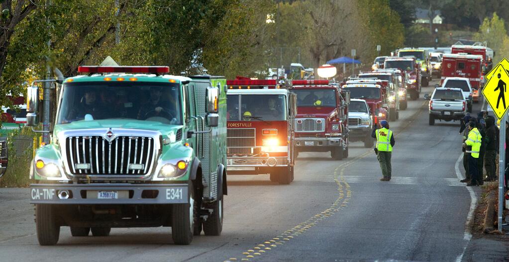 Fire trucks heading back to the front lines or heading back to their home stations head down Brookwood Ave. at the Sonoma County Fairgrounds early Saturday morning. (photo by John Burgess/The Press Democrat)