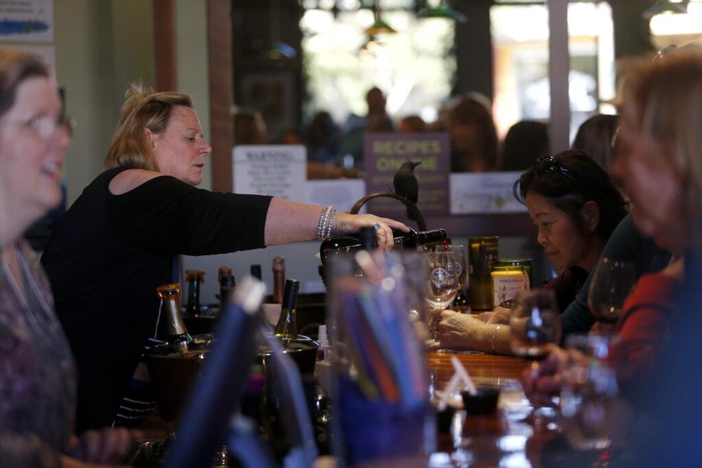 Employee Cheryl Lynd pours wine for patrons at Toad Hollow Vineyards tasting room as part of the Wine Road's Food and Wine Affair on Sunday, November 5, 2017 in Healdsburg, California . (BETH SCHLANKER/The Press Democrat)