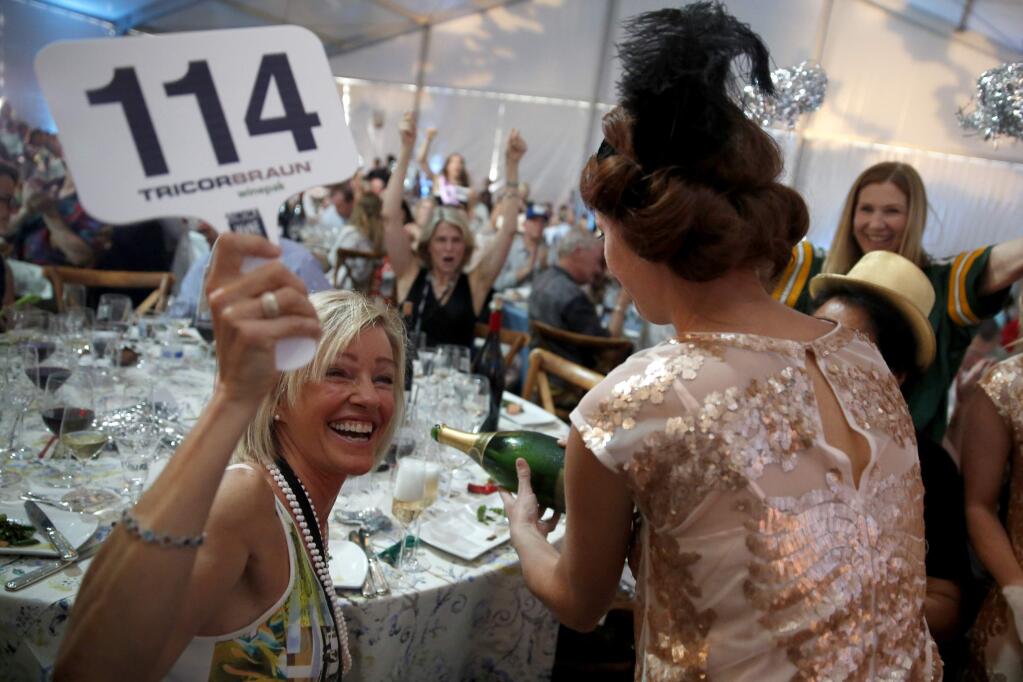 Kim Kiyosaki wins a Super Bowl lot during the Sonoma Harvest Wine Auction at Chateau St. Jean on Sunday, September 6, 2015 in Kenwood, California . (BETH SCHLANKER/ The Press Democrat)