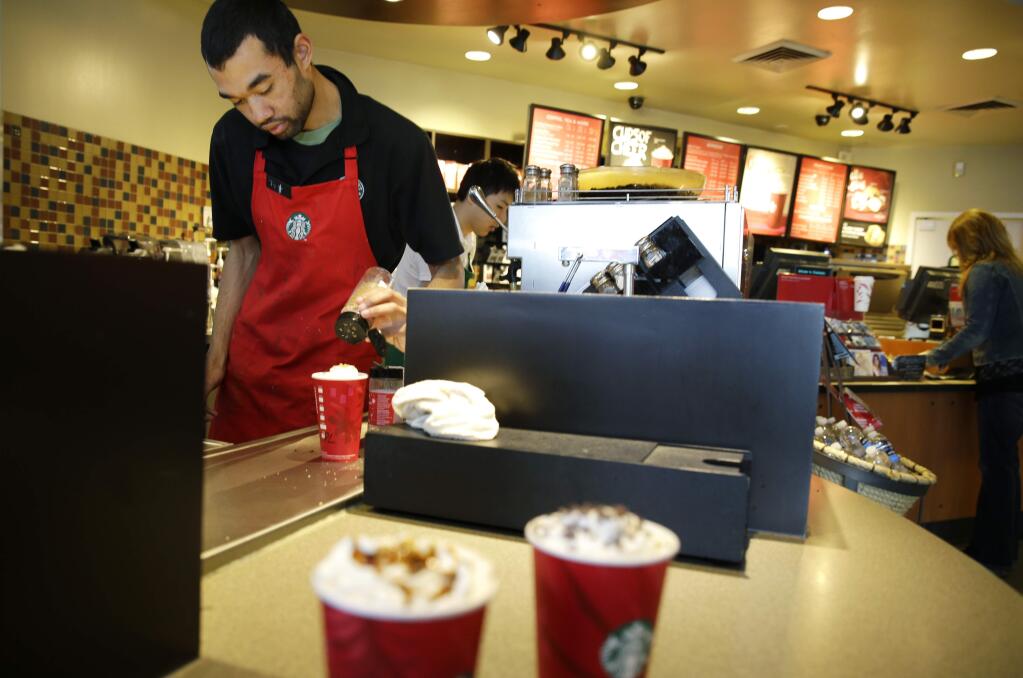 FILE - In this Nov. 24, 2014, file photo, barista Jay Rapp prepares a Chestnut Praline Latte at a Starbucks store in Seattle. Starbucks on Monday, April 6, 2015, said its workers can now have four years of tuition covered for an online college degree from Arizona State University instead of just two, marking the latest sign that companies are rethinking their treatment of low-wage workers. (AP Photo/Ted S. Warren, File)
