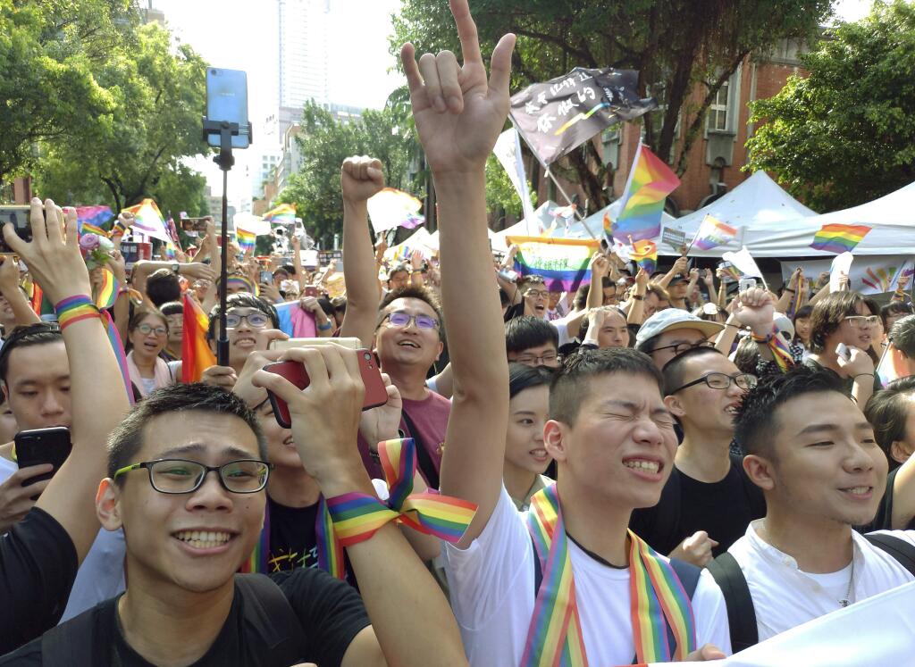 Same-sex marriage supporters cheer outside the Legislative Yuan Friday, May 17, 2019, in Taipei, Taiwan after the legislature passed a law allowing same-sex marriage in a first for Asia. The vote Friday allows same-sex couples full legal marriage rights, including in areas such as taxes, insurance and child custody. (AP Photo/Chiang Ying-ying)