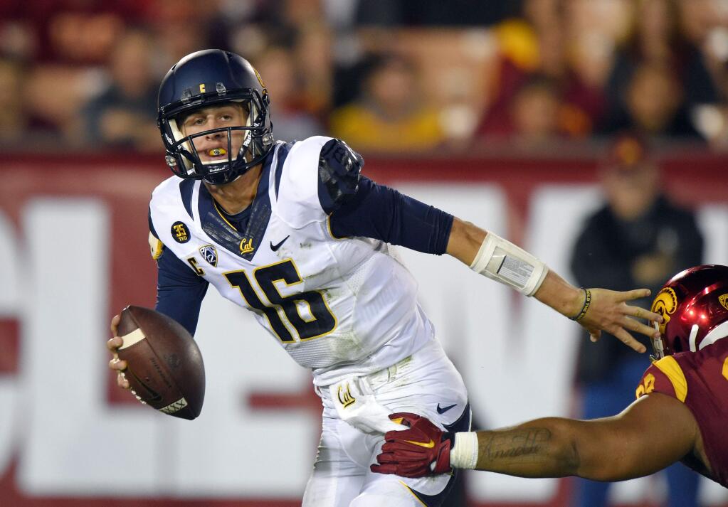 California quarterback Jared Goff, left, tries to pass under pressure from USC defensive tackle Antwaun Woods during the first half of a game, Thursday, Nov. 13, 2014, in Los Angeles. (AP Photo/Mark J. Terrill)