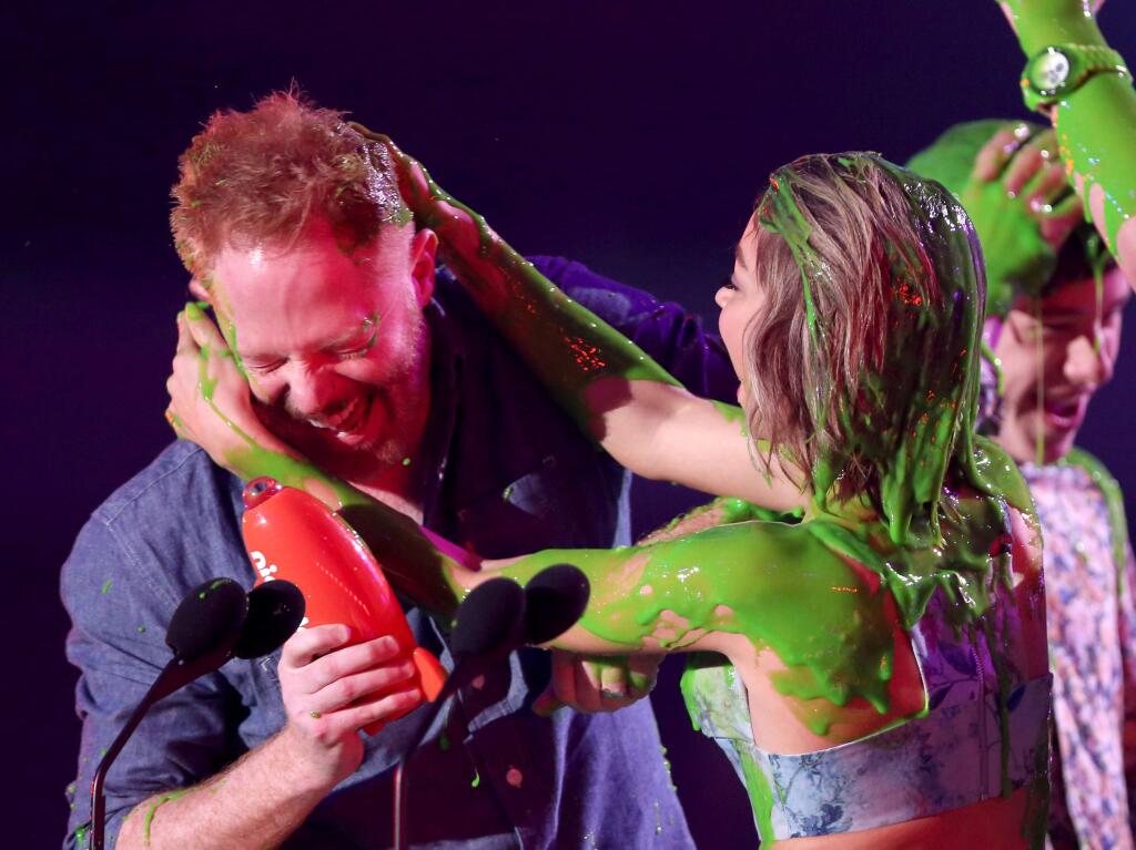 Jesse Tyler Ferguson, left, and Sarah Hyland are slimed after being announced winners of the award for favorite family TV show for Modern Family at Nickelodeon's 28th annual Kids' Choice Awards at The Forum on Saturday, March 28, 2015, in Inglewood, Calif. (Photo by Matt Sayles/Invision/AP)