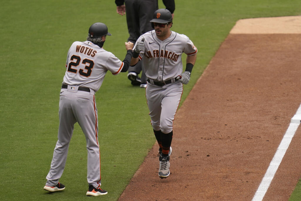 San Francisco Giants' Mike Tauchman, right, is greeted by third base coach Ron Wotus (23) after hitting a three-run home run during the third inning of a baseball game against the San Diego Padres, Sunday, May 2, 2021, in San Diego. (AP Photo/Gregory Bull)