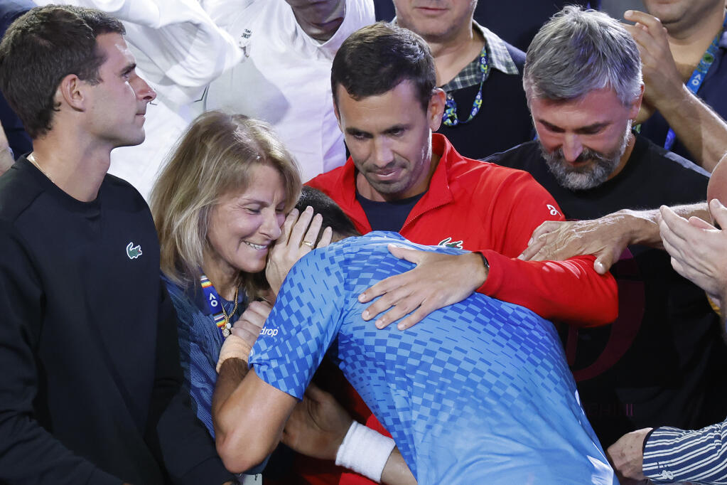 Novak Djokovic of Serbia, center, celebrates with his team including his mother, Dijana, second left, after defeating Stefanos Tsitsipas of Greece in the men's singles final at the Australian Open tennis championships in Melbourne, Australia, Sunday, Jan. 29, 2023. (AP Photo/Asanka Brendon Ratnayake)