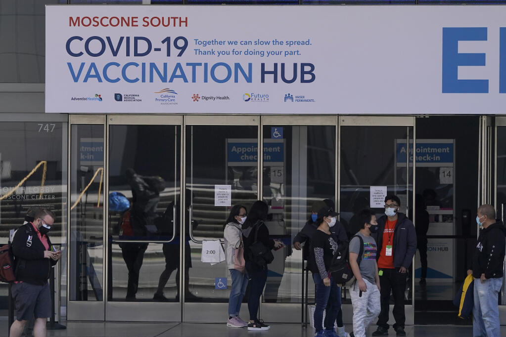 People walk outside a COVID-19 vaccination site at Moscone Center South during the coronavirus pandemic in San Francisco, Thursday, March 25, 2021. (AP Photo/Jeff Chiu)