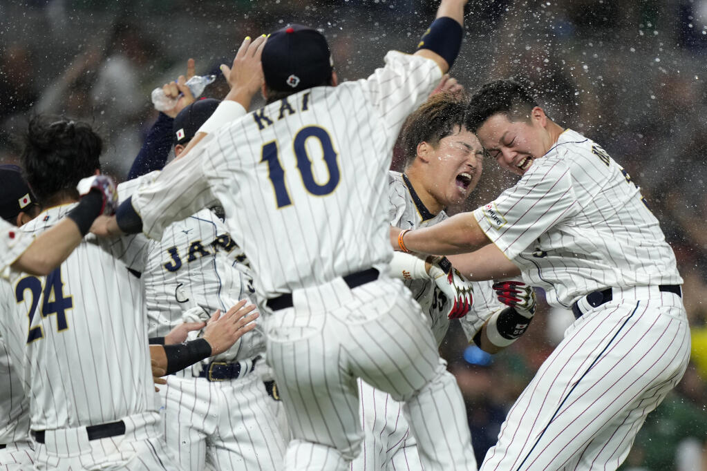Japan players celebrate after defeating Mexico in a World Baseball Classic game, Monday, March 20, 2023, in Miami. (AP Photo/Wilfredo Lee)
