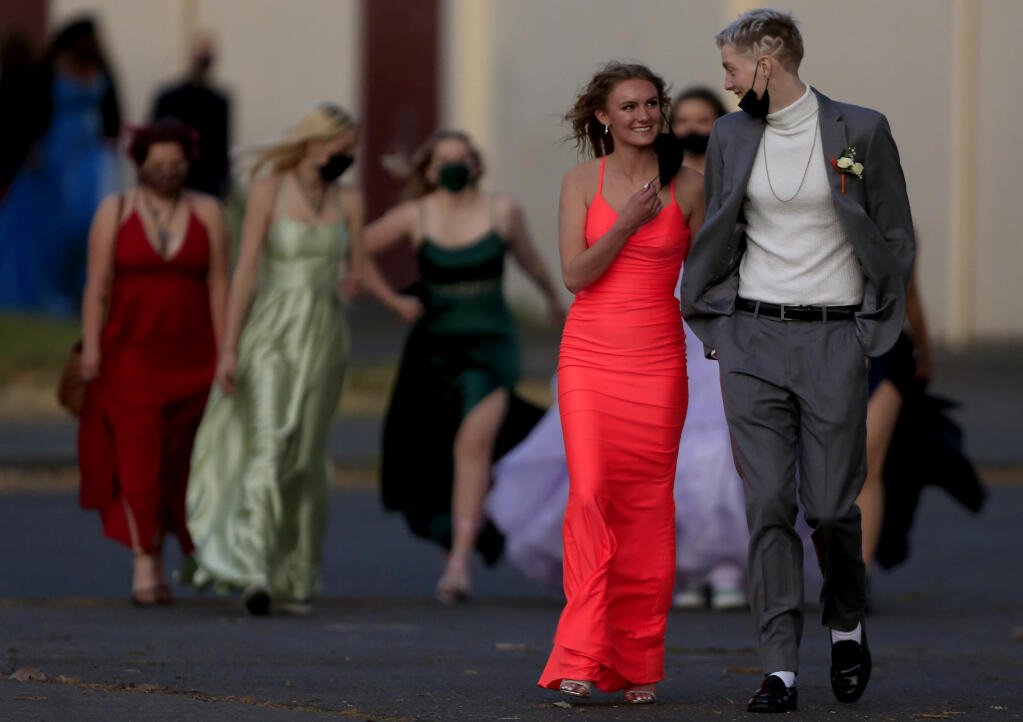 Santa Rosa High School students make the trek across campus to their prom on the school football field, Saturday, May 1, 2021 in Santa Rosa. The students were required to have a negative COVID test or be fully vaccinated.  (Kent Porter / The Press Democrat) 2021