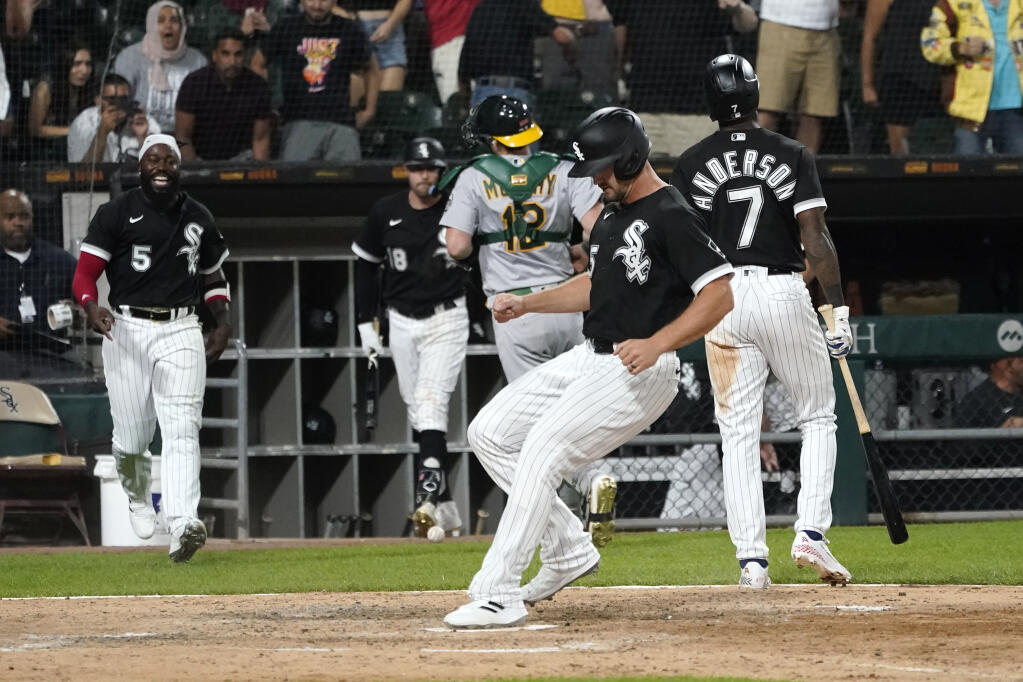 Chicago White Sox's Adam Engel scores on a wild pitch from Oakland Athletics relief pitcher Zach Jackson to give the White Sox a 3-2 win during during the ninth inning of a baseball game Saturday, July 30, 2022, in Chicago. (AP Photo/Charles Rex Arbogast)