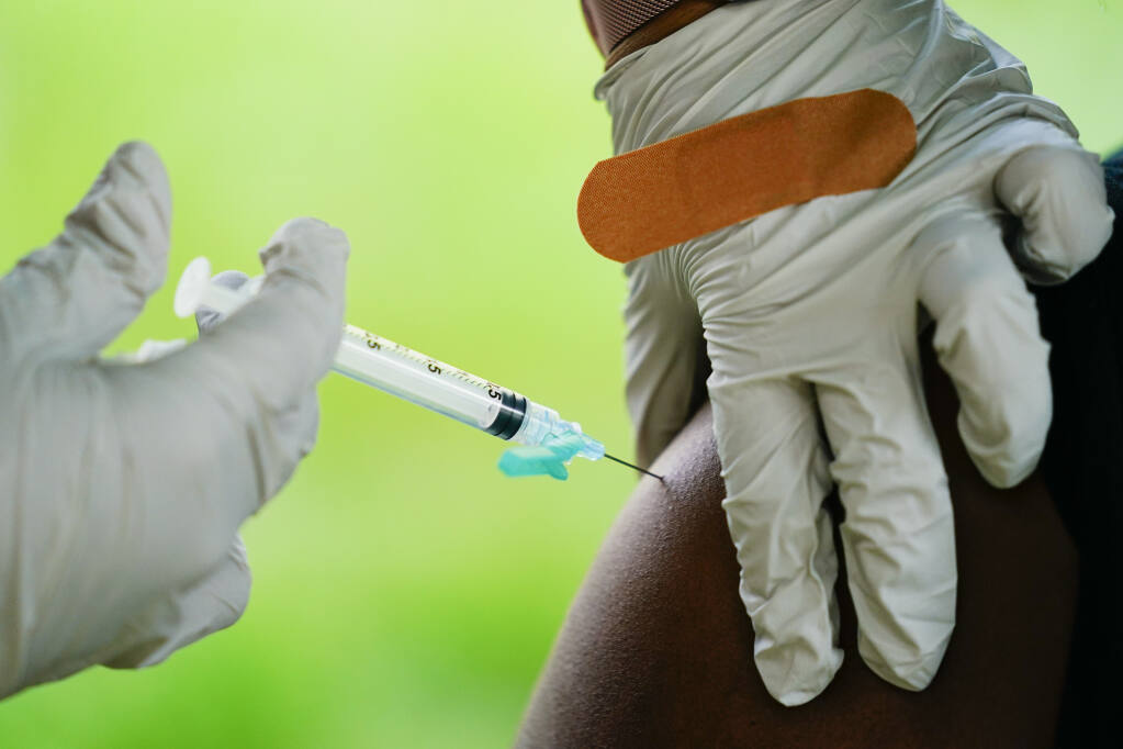 A health worker administers a dose of COVID-19 vaccine during a vaccination clinic. Experts say that while vaccines may not prevent infection by omicron subvariants, they lessen the severity of the symptoms. (AP Photo/Matt Rourke, File)