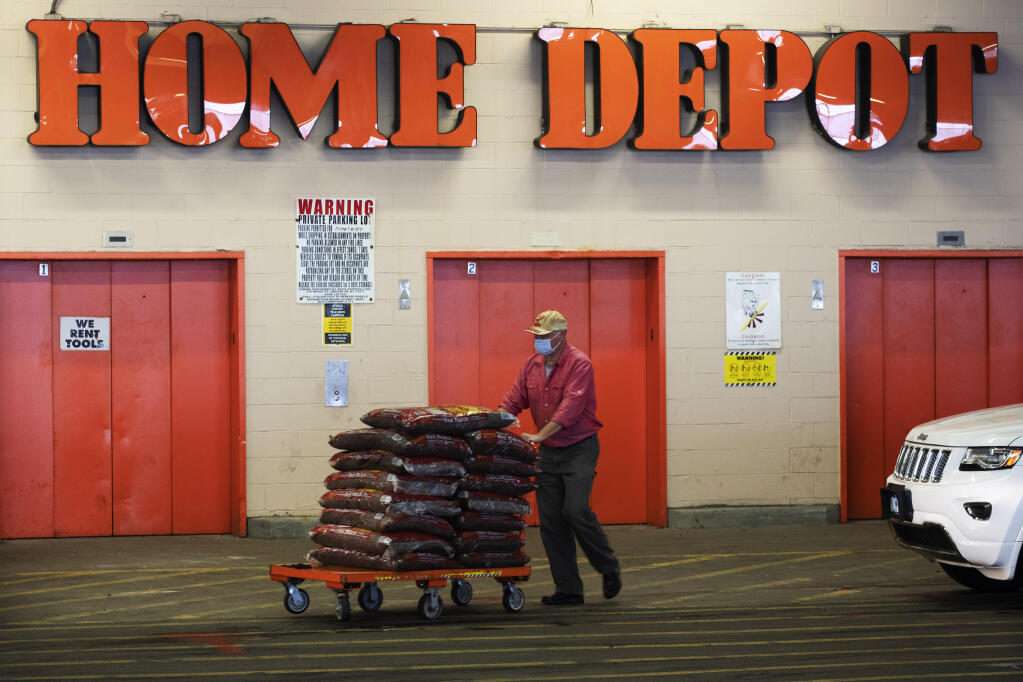 AHome Depot customer pushes a cart loaded with supplies in New York on April 3. Home Depot is buying HD Supply Co.,  a distributor of maintenance, repair and operations products in the multifamily and hospitality end markets, in a deal valued at about $8 billion. The transaction is expected to close during Home Depot's fiscal fourth quarter. (AP Photo/Mark Lennihan, File)