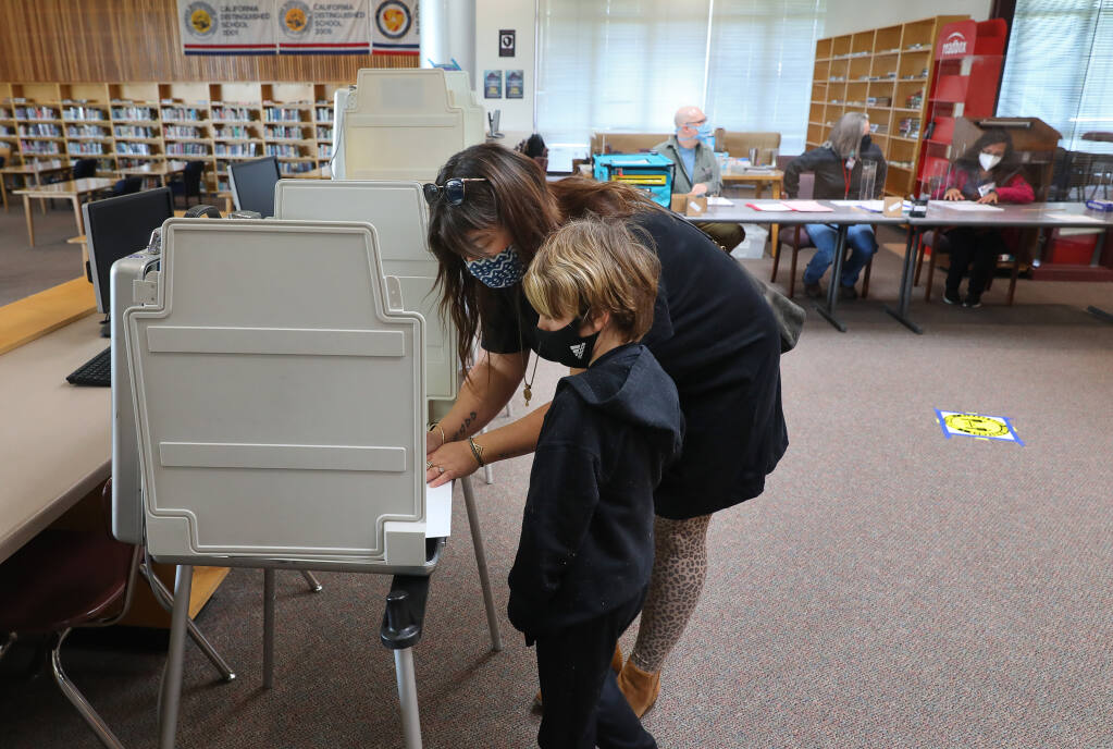 Amy Palmer fills out her ballot with her son, Reed, at the El Molino High School library polling location in Forestville on Tuesday, March 2, 2021.  (Christopher Chung/ The Press Democrat)