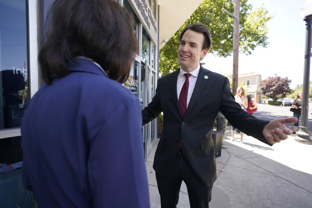 FILE — In this July 22, 2021 file photo Assemblyman Kevin Kiley, a Republican candidate for governor in the Sept. 14 recall election, talks with a supporter during a campaign event for school choice outside a charter school in Sacramento, Calif. Kiley, 36, who has been one of Democratic Gov. Gavin Newsom's chief critics in the Legislature, is among 46 candidates seeking to replace him in the Sept. 14th recall election. (AP Photo/Rich Pedroncelli, File)