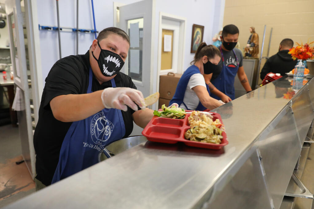 Jennifer Ramos prepares a tray of food for a client at St. Vincent de Paul Community Kitchen in Santa Rosa on Thursday, Oct. 22, 2020. (Christopher Chung / The Press Democrat)