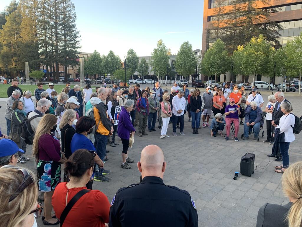Attendees hold a moment of silence Tuesday, May 31, 2022, during a candlelight vigil in Santa Rosa. U.S. Rep. Mike Thompson, D-St. Helena, held it to honor victims of the recent Texas school shooting and raise awareness of gun violence. (Colin Atagi / The Press Democrat)