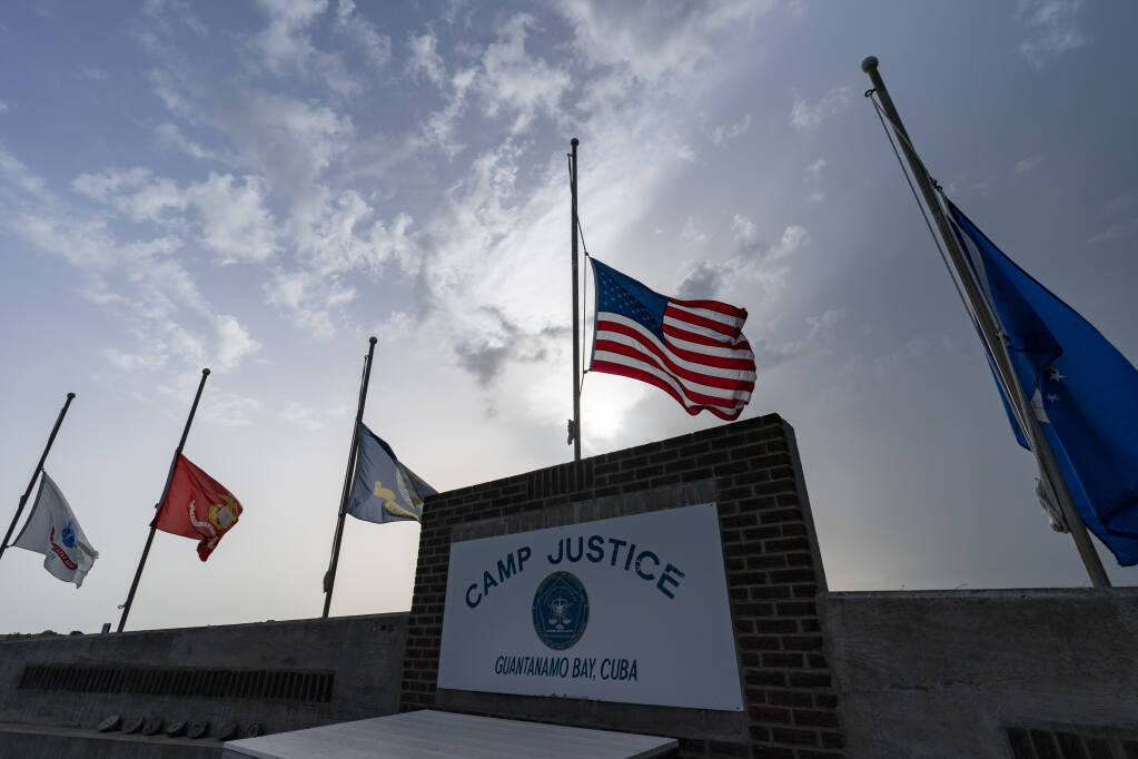 FILE - In this photo reviewed by U.S. military officials, flags fly at half-staff at Camp Justice, Aug. 29, 2021, in Guantanamo Bay Naval Base, Cuba. Majid Khan, the onetime courier for al-Qaida is a free man after serving more than 16 years at Guantanamo, and surviving torture at notorious CIA "black sites." The Pentagon announced the release of Pakistan citizen Khan on Thursday, Feb. 2, 2023. Khan is now in Belize, after that nation reached agreement with the Biden administration to take him. (AP Photo/Alex Brandon, File)
