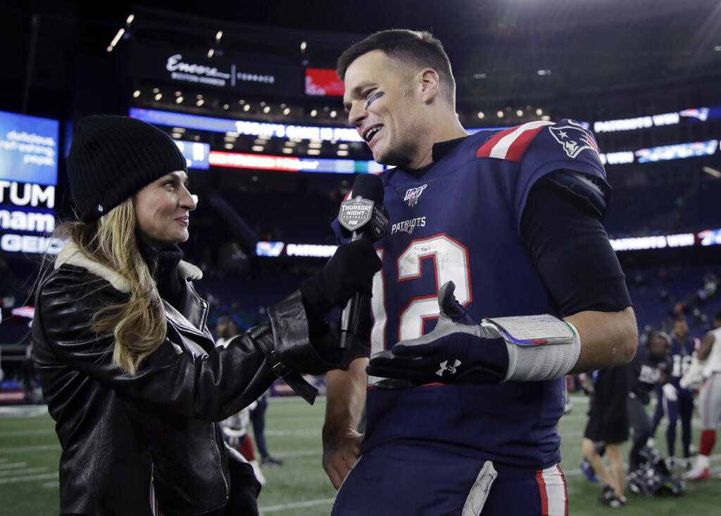 FILE - Fox Sports television sideline broadcast reporter Erin Andrews, left, interviews then-New England Patriots quarterback Tom Brady at midfield after an NFL football game between the Patriots and the New York Giants, Thursday, Oct. 10, 2019, in Foxborough, Mass. Seven-time Super Bowl champion Tom Brady will join Fox sports as its lead football analyst once his playing career ends, the network said on Tuesday, May 10, 2022. When that actually happens is unclear, since Brady recently renounced his announced retirement and said he plans to continue playing for the Tampa Bay Bucs. (AP Photo/Elise Amendola, File)