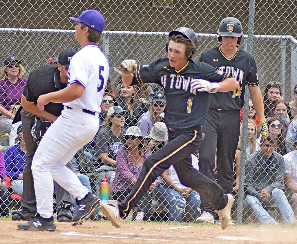 Ukiah's Trenton Ford, center, scores on a wild pitch during the North Coast Section Division 2 championship game at Petaluma High on Saturday, May 28, 2022. (Sumner Fowler / FOR THE PETALUMA ARGUS-COURIER)
