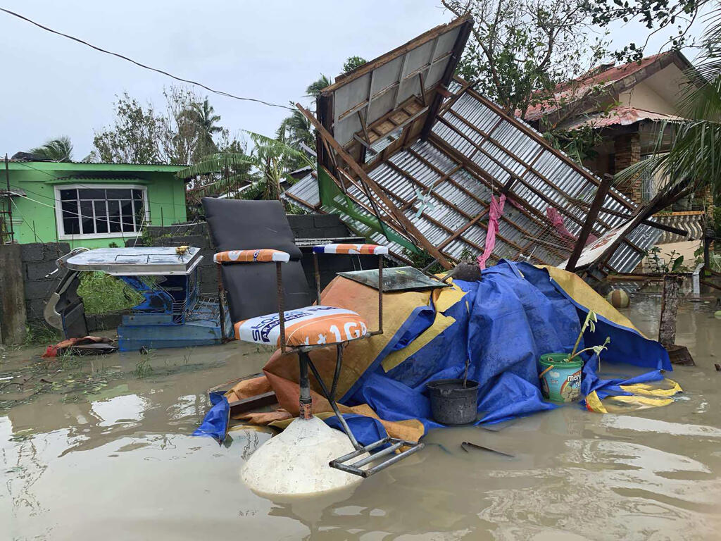 The remains of a barbershop is surrounded by floods in Pola town on the island of Mindoro, central Philippines on Monday, Oct. 26, 2020. A fast moving typhoon has forced thousands of villagers to flee to safety in provinces. (AP Photo/Erik De Castro)