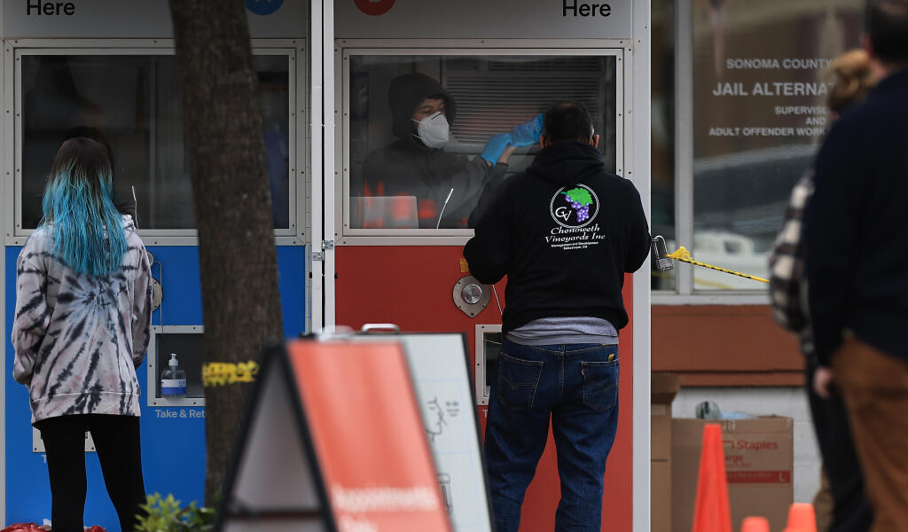 Sonoma County residents perform a self test for Covid-19 at a Curative site to the rear of Dicks Sporting Goods, Wednesday, Jan. 5, 2022 in Santa Rosa.  (Kent Porter / The Press Democrat) 2022