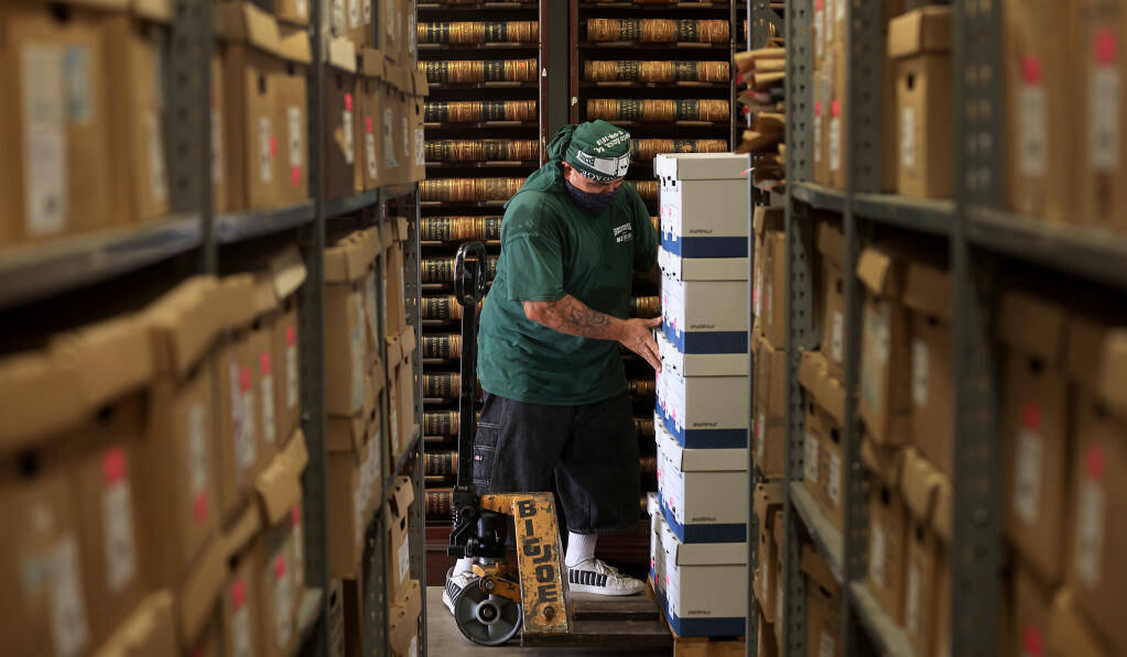 Vincent Villalobos a mover with Schultz Brothers Van & Storage, Inc. removes boxed historical Sonoma County records from a warehouse at Los Guilicos near Oakmont on Aug. 20, 2021.  The records are being moved to a new location in Santa Rosa because of the inherent fire danger from the surrounding Mayacamas Mountains. (Kent Porter / The Press Democrat)