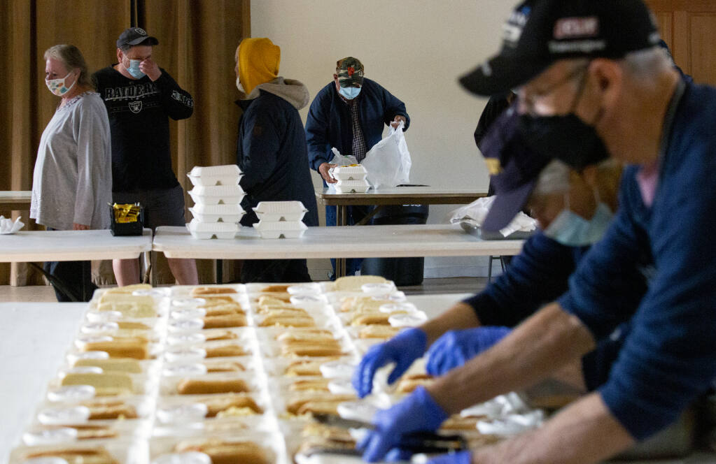 Volunteers for SOS continue to prepare packaged lunches of hot dogs, chili and macaroni salad as the doors open and anyone is free to take whatever they need at Sonoma Springs Community Hall on Thursday, Nov. 18, 2021. (Photo by Robbi Pengelly/Index-Tribune)