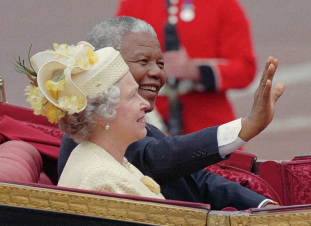 Queen Elizabeth II and South African President Nelson Mandela greet well-wishers in London in 1996, a year after the queen’s visit to South Africa. (LOUISA BULLER / Associated Press)