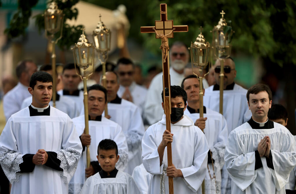 Acolytes and deacons lead the procession of the Eucharist, Thursday, June 16, 2021 along Sonoma Ave. in Santa Rosa.  A group of about 200 Santa Rosa Diocese parishioners marched from St. Rose of Lima Catholic Church to St. Eugene's Cathedral.  (Kent Porter / The Press Democrat) 2022