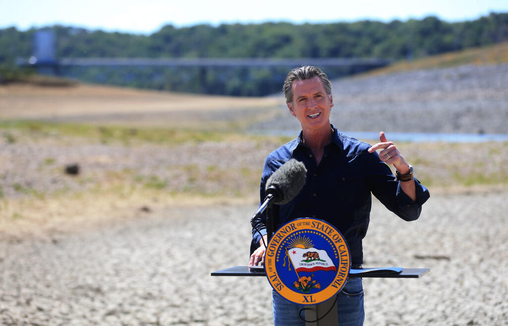 Gov. Gavin Newsom, standing on the dry bed of Lake Mendocino, accounces a drought emergency in Sonoma and Mendocino counties. (KENT PORTER / The Press Democrat)