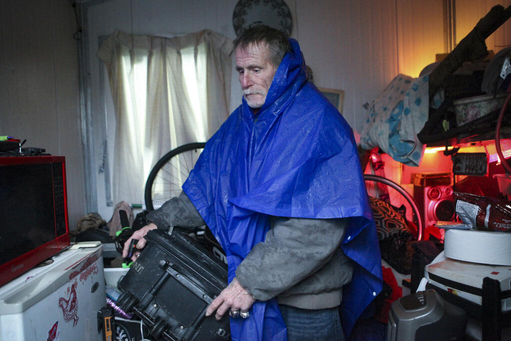 Jeff Odell pulls out a suitcase that has evidence of mold due to wet conditions inside his tiny home on Tuesday, January 10, 2023. He claims rainwater drips from the roof and seeps onto the floors. (CRISSY PASCUAL/ARGUS-COURIER STAFF)