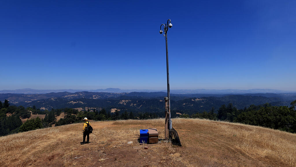 Shepley Schroth-Cary, Goldridge Fire Protection District's chief, looks over the view at the site of UC San Diego's Alert California fire cameras at the Pole Mountain Preserve, Wednesday, July 12, 2023. Cary was part of a team of firefighters, teamed with Cal Fire and Sonoma Land Trust, for a prescribed burn just below the camera site. Middle left is Mount St. Helena.  (Kent Porter / The Press Democrat)