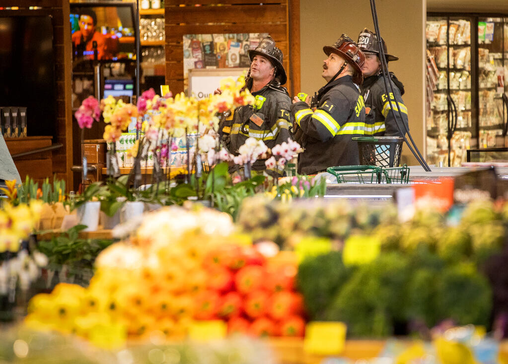 Santa Rosa firefighters mop up after a fire in the HVAC system on the roof of Whole Foods Market in Coddingtown Mall, Thursday, Jan. 12, 2023. The store was closed for repairs.  (John Burgess/The Press Democrat)