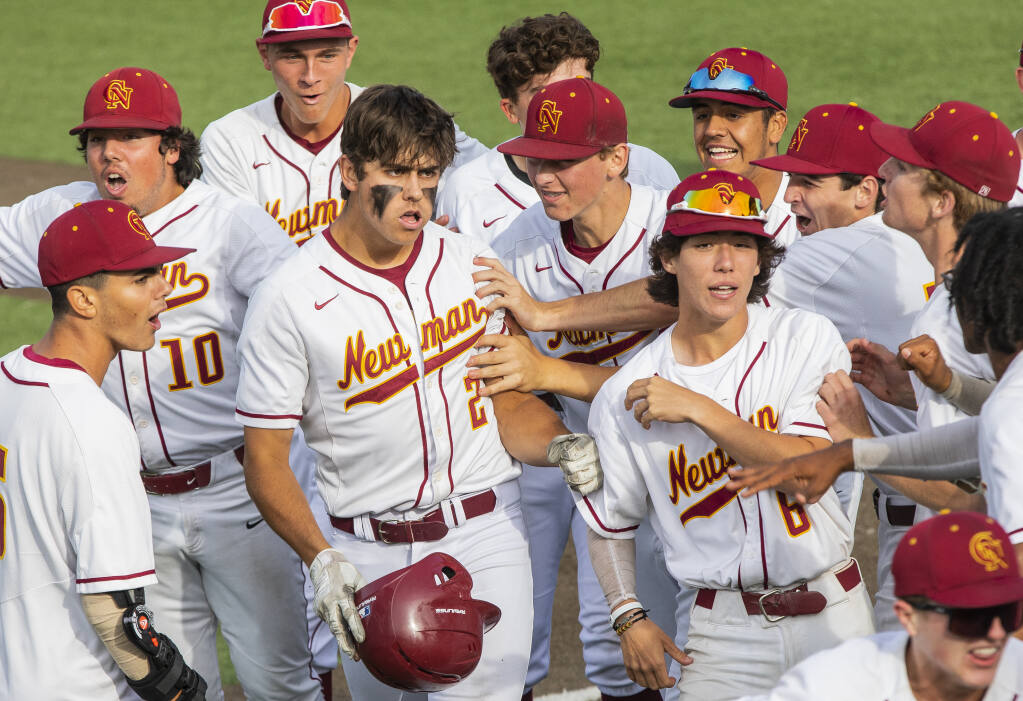 Cardinal Newman’s bench swarms Gavin Rognlien as they celebrate his 5th-inning home run during their championship game against San Marin at Cardinal Newman,  Friday May 27, 2022. (Chad Surmick / The Press Democrat)