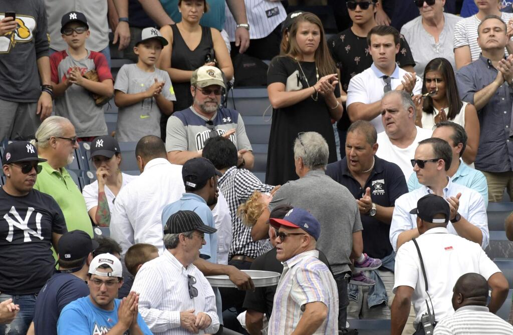Baseball fans reacts as a young girl is carried out of the seating area after being hit by a line drive during the fifth inning of a baseball game between the New York Yankees and Minnesota Twins, Wednesday, Sept. 20, 2017, at Yankee Stadium in New York. (AP Photo/Bill Kostroun)