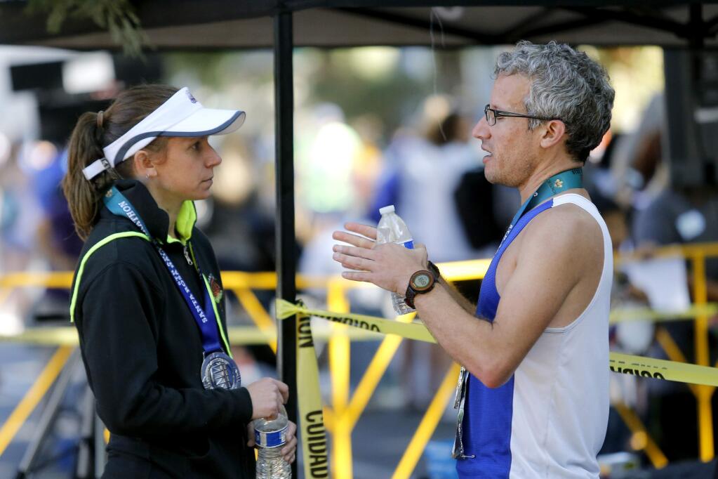 Abraham Sheppard tries to argue his case with Beth Carter, the pace team coordinator for the Santa Rosa Marathon, after he failed to qualify for the Boston Marathon because of an .9-mile detour accidentally taken by the pace-setter. Photo taken at the finish of the Santa Rosa Marathon at Juilliard Park on Sunday, August 28, 2016 in Santa Rosa, California . (BETH SCHLANKER/ The Press Democrat)