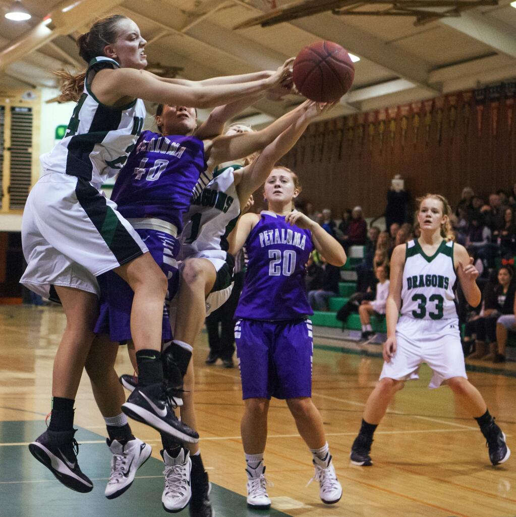 Sonoma's Renee O'Donnell (left) and Sami Von Gober (middle, No. 1) overpower a Trojan player for the ball as teammate Grace Cutting (right), follows the play on Tuesday, 13 Jan, in Pfeiffer Gym. The Lady Dragons plowed past Petaluma with a 46-34 victory. (Photos by Robbi Pengelly/Index-Tribune)