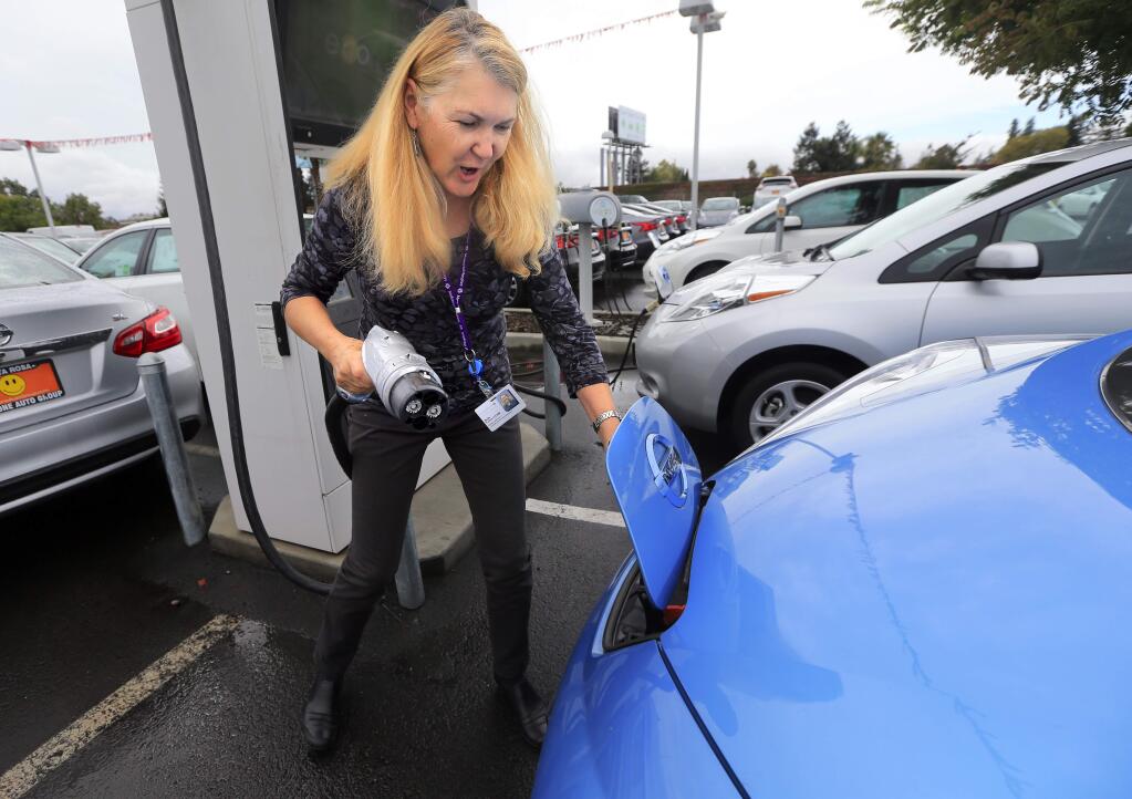 Beth Fulton charges her Nissan Leaf at Jim Bone Nissan in Santa Rosa on October 14, 2016. (John Burgess/The Press Democrat)