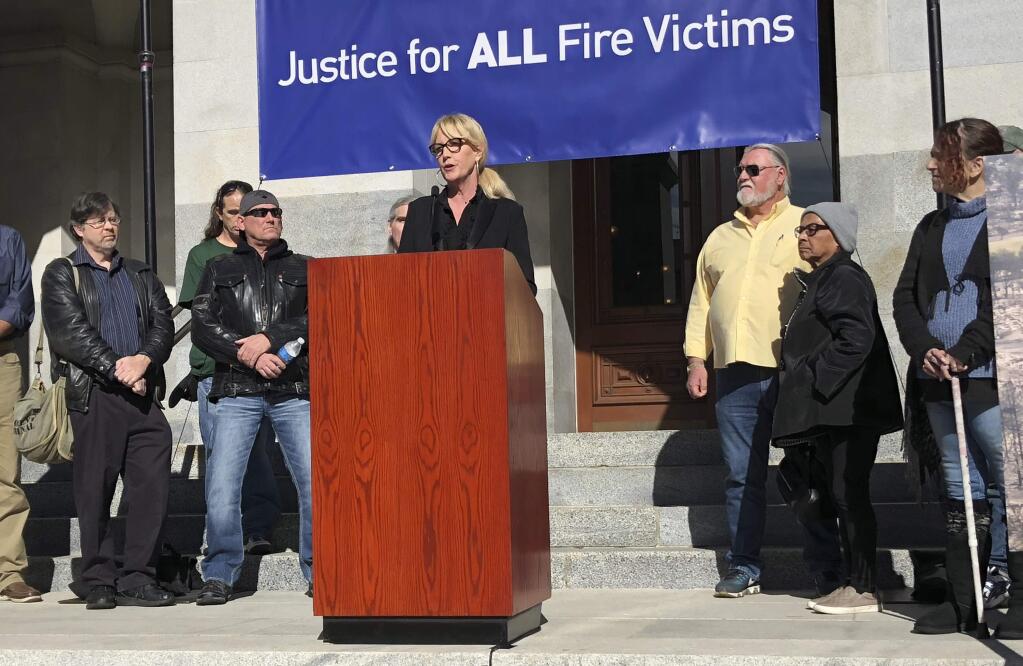 Consumer advocate Erin Brockovich, who famously took on Pacific Gas & Electric Co. in the 1990s, stands with wildfire victims and speaks outside the state Capitol Tuesday, Jan. 22, 2019, in Sacramento, Calif. Brockovich is urging California lawmakers not to let PG&E go bankrupt because it might mean less money for wildfire victims. (AP Photo/Kathleen Ronayne)